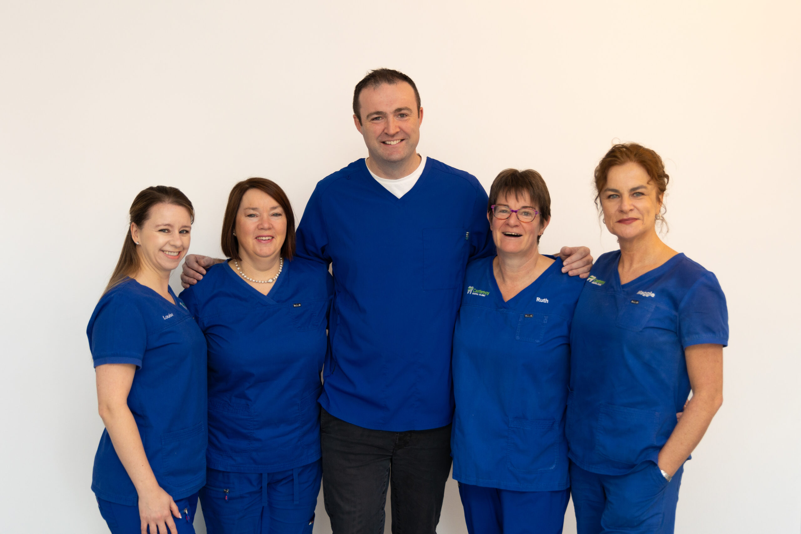 The full Castletroy Dental Clinic team of dentists, hygienists and dental nurses together in blue scrubs