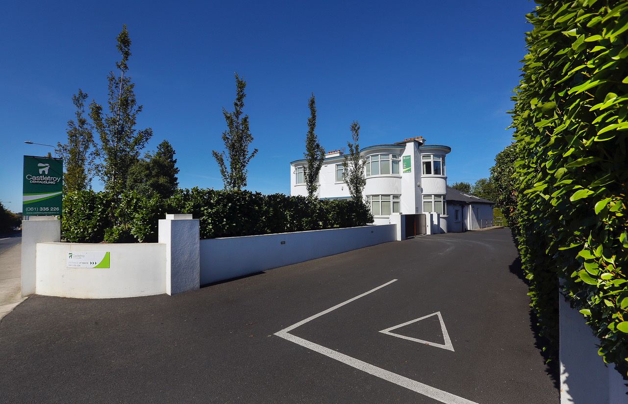 The green Castletroy Dental Clinic signpost and wide tarmac driveway at the Dublin Road entrance in Castletroy, Limerick